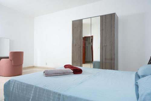 a bedroom with a blue bed and a mirror at Belle demeure spacieuse 2 in Mamoudzou