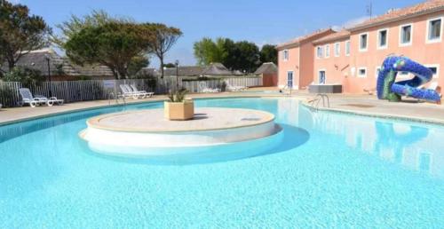 une grande piscine avec une fontaine au milieu dans l'établissement Mas bleu île des pêcheurs, au Barcarès