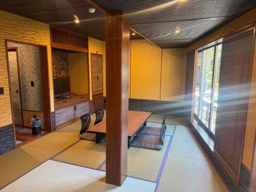a room with a table and chairs and a window at Hakone Onsen Ryokan Yaeikan in Hakone