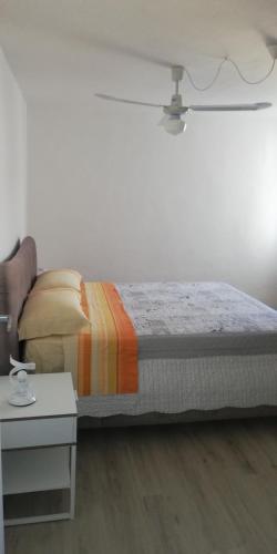 a bed in a white room with a white table at Casa Marina in Foligno