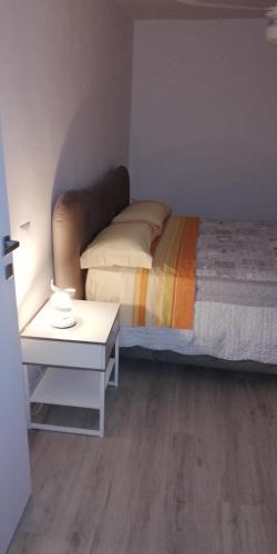 a small bedroom with a bed and a table at Casa Marina in Foligno