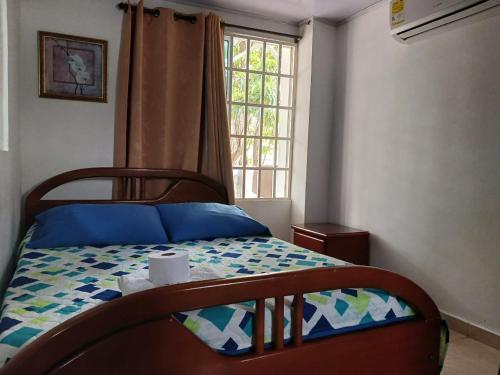 a bedroom with a bed with a comforter and a window at HABITACIÓN INDEPENDIENTE y APARTAESTUDIO MONOAMBIENTE in Barranquilla