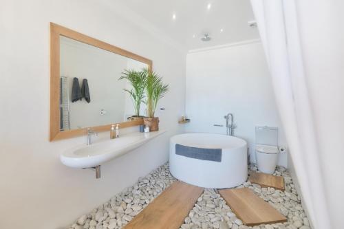 a bathroom with a tub and a sink and a toilet at Oceans Guest House & Luxurious Apartments in Struisbaai