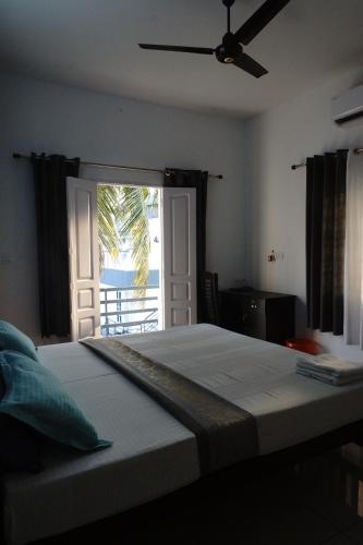 - une chambre avec un lit et une porte donnant sur une terrasse dans l'établissement Nest, à Cochin