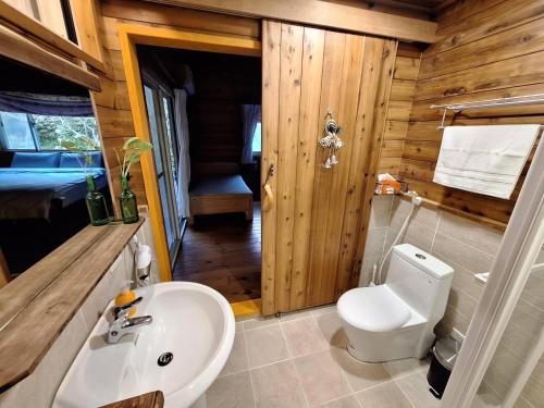 La salle de bains est pourvue de toilettes et d'un lavabo dans une cabine. dans l'établissement Wen Qiao Villa, à Nanzhuang
