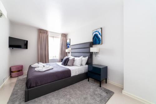 a bedroom with a bed and a flat screen tv at Stylish 1 bedroom apartment in Maida Vale in London