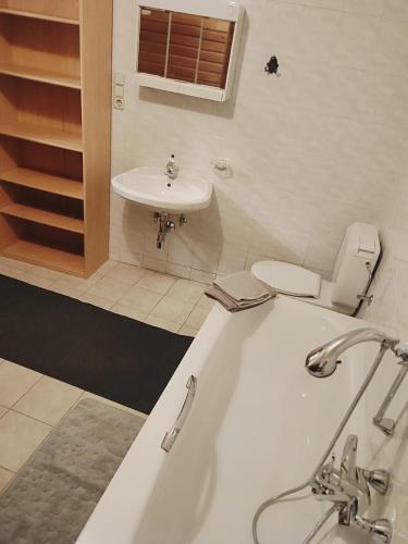 a bathroom with a tub and a toilet and a sink at Altstadthaus Marille mit Innenhofterrasse in Melk