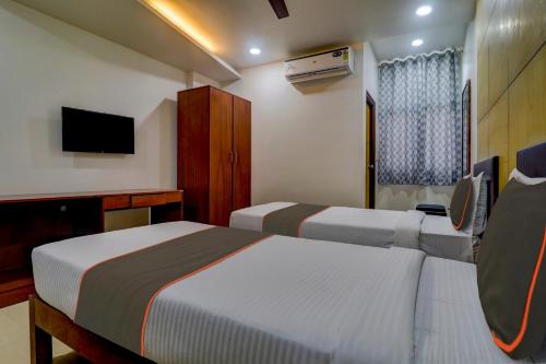 um quarto de hotel com duas camas e uma televisão em Qualia Heights Madhapur Beside Cyber Tower em Hyderabad