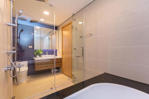 a bathroom with a tub and a glass shower at Căn Hộ Vũng Tàu in Xa Thang Nhut