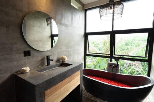 bagno con ampia vasca e specchio di Casaluna 1, Canggu industrial townhouse with private pool a Dalung