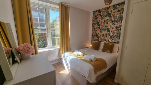 The Pearl of Greenwich - Two bedroom flat next to Cutty Sark في لندن: غرفة نوم عليها سرير وفوط