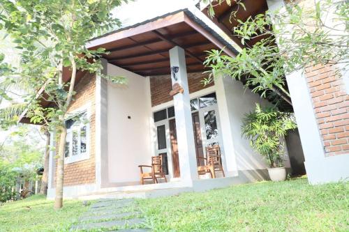 a porch of a house with chairs and trees at Hotel Ro Kalawewa - Anuradhapura District in Kalawewa Walauwa