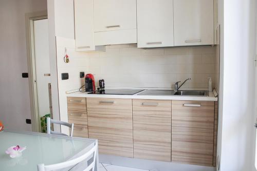 a kitchen with white cabinets and a sink at Casa Giulia in Cuneo