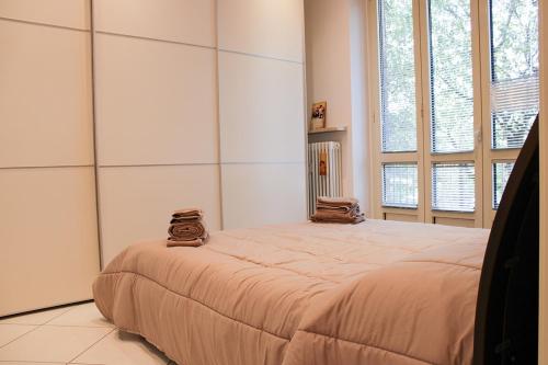 un grande letto in una stanza con due finestre di Casa Giulia a Cuneo