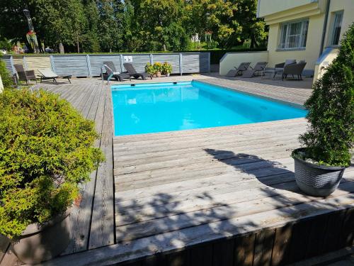 a swimming pool on a wooden deck with chairs at "Indian Summer" Apartment in Viljandi