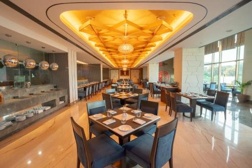 a restaurant with tables and chairs in a room at Radisson Blu Pune Hinjawadi in Pune