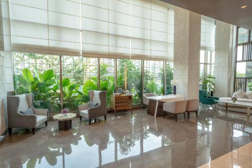 a lobby with chairs and a table and windows at Radisson Blu Pune Hinjawadi in Pune