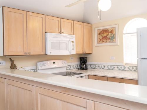 uma cozinha com armários de madeira e um aparelho branco em Deluxe Ocean View Villas - Just Steps From White Sand Beaches em Creek Village