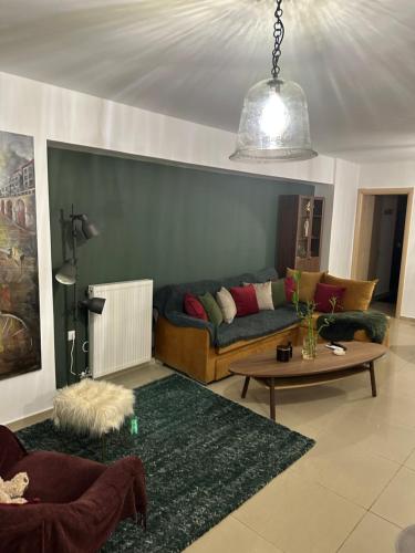 ein Wohnzimmer mit einem Sofa und einem Tisch in der Unterkunft Little John Luxury Apartment in Piräus