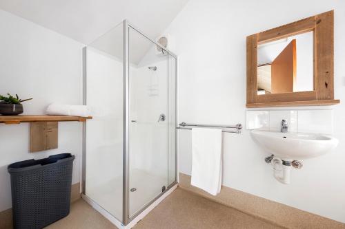 a bathroom with a glass shower and a sink at Scamander Sanctuary Holiday Park in Scamander