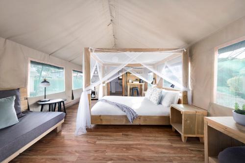 um quarto com uma cama de dossel numa tenda em Scamander Sanctuary Holiday Park em Scamander