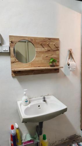lavabo en el baño con espejo en la pared en Grandpa House 爷爷老家, en Gopeng