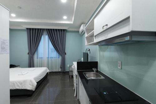 una cucina con lavandino e un letto in una camera di NEW MILANO HOTEL & APARTMENT ad Ho Chi Minh