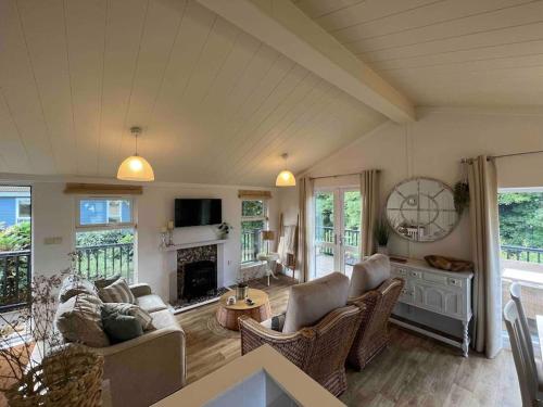 a living room with a couch and a fireplace at Waterside Lodge, Weybourne, Holt in Weybourne