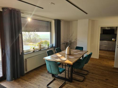 comedor con mesa, sillas y ventana en Moderne Ferienwohnung mit Aussicht, en Bad Oeynhausen