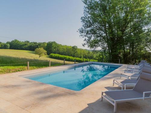 a swimming pool with lounge chairs around it at Holiday home with swimming pool in Saint-Laurent-la-Vallée