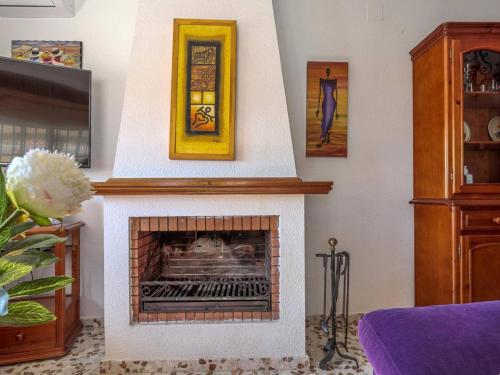 a living room with a fireplace with two pictures at La Fonda de Julia Magnifica casa muy luminosa y amplia con chimenea y barbacoa in Matalascañas