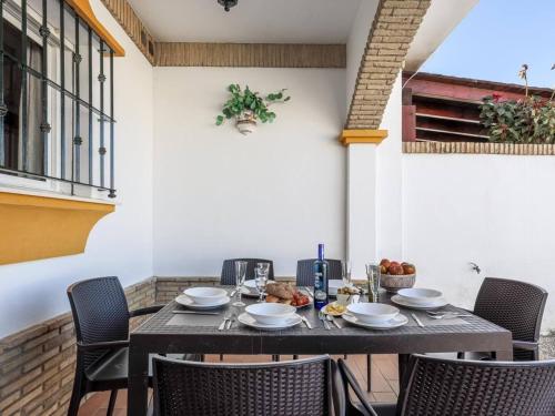 a table and chairs in a patio with a table and chairsktop at La Fonda de Julia Magnifica casa muy luminosa y amplia con chimenea y barbacoa in Matalascañas