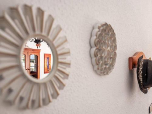 a mirror hanging on a wall next to a wall at La Fonda de Julia Magnifica casa muy luminosa y amplia con chimenea y barbacoa in Matalascañas