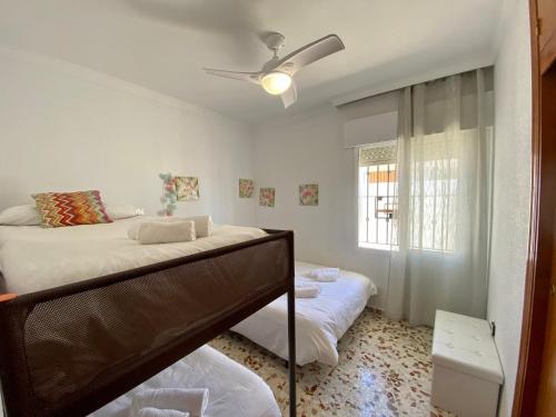 a bedroom with two beds and a window at La Fonda de Julia Magnifica casa muy luminosa y amplia con chimenea y barbacoa in Matalascañas