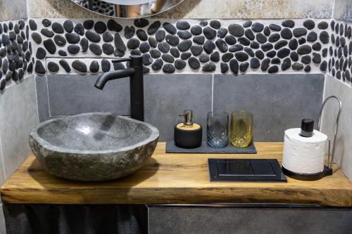 un lavandino in bagno con ciotola in pietra e rubinetto di Apartment Serdika 1 a Sofia