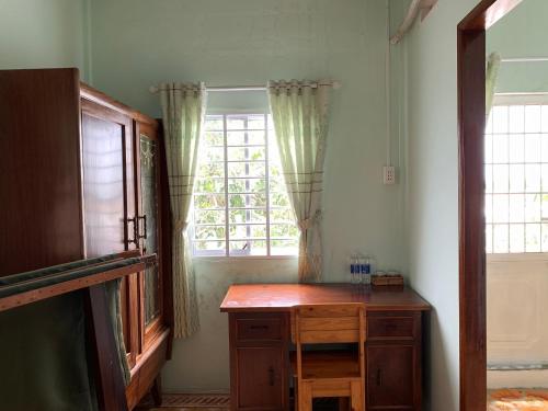 a room with a wooden desk and a window at ISLAND HOMESTAY TIỀN GIANG in Ấp Tân An Thi