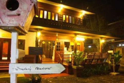 a house with a sign in front of it at night at BaanChompooAmphawa in Amphawa