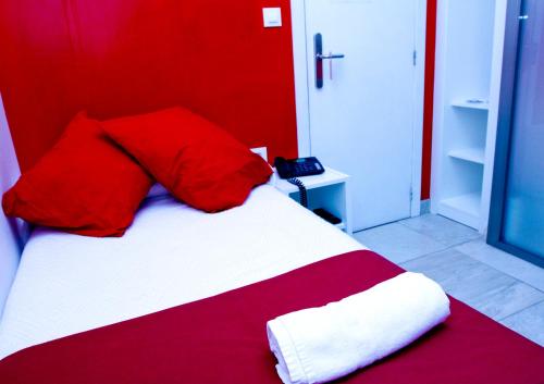 a red and white bed in a room with a phone at Nest Style Granada in Granada