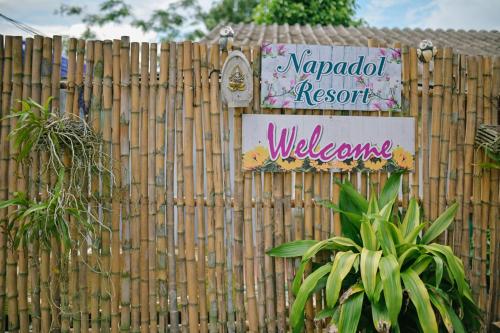 a fence with a sign that reads napadi resort welcome at ไร่นภาดลรีสอร์ท in Mae Suai