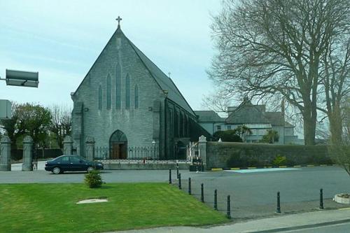 Presentation Convent في Mooncoin: كنيسة فيها سيارة متوقفة امامها