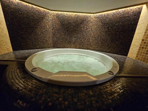 a tub in a bathroom with a tiled wall at "Winter" Apartment in Viljandi