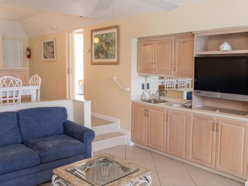 a living room with a blue couch and a tv at Sun View Villas at Paradise Island Beach Club in Creek Village