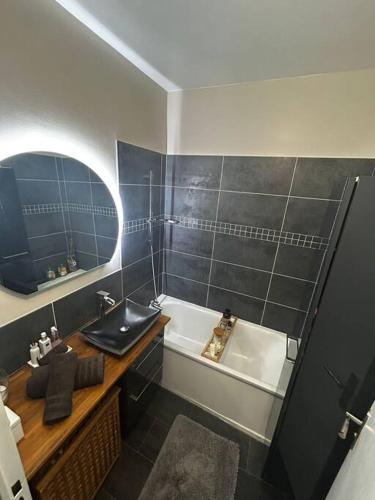 une salle de bain avec un lavabo et une baignoire dans l'établissement Confort cosy, à Paris