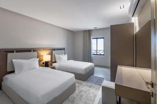 Cette chambre comprend deux lits et un bureau. dans l'établissement شقة غرفتين وصالة ومطبخ, à Médine
