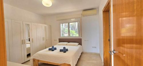 a white bedroom with a bed and a window at Oliver House in Tarragona