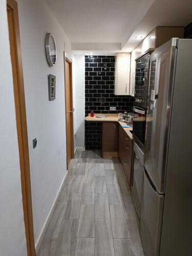 a kitchen with a refrigerator and a tile floor at Alojamiento turístico MN in Seville