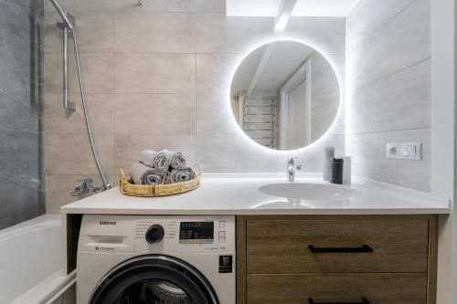 uma casa de banho com uma máquina de lavar roupa e um lavatório em InshiApartments on Slovatskoho str em Lviv