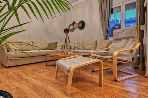 a living room with a couch and chairs and a table at Living Life Apartment Komotini in Komotini