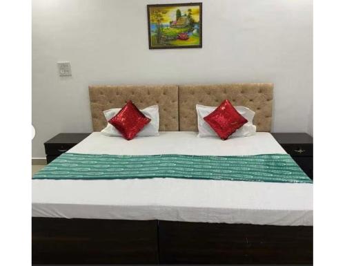a bed with red and white pillows on it at Hotel Subh Ratri, Jhansi in Jhānsi