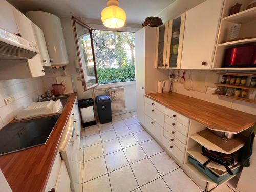 Elle comprend une petite cuisine avec des placards blancs et une fenêtre. dans l'établissement Appart Saint Raph', à Saint-Raphaël